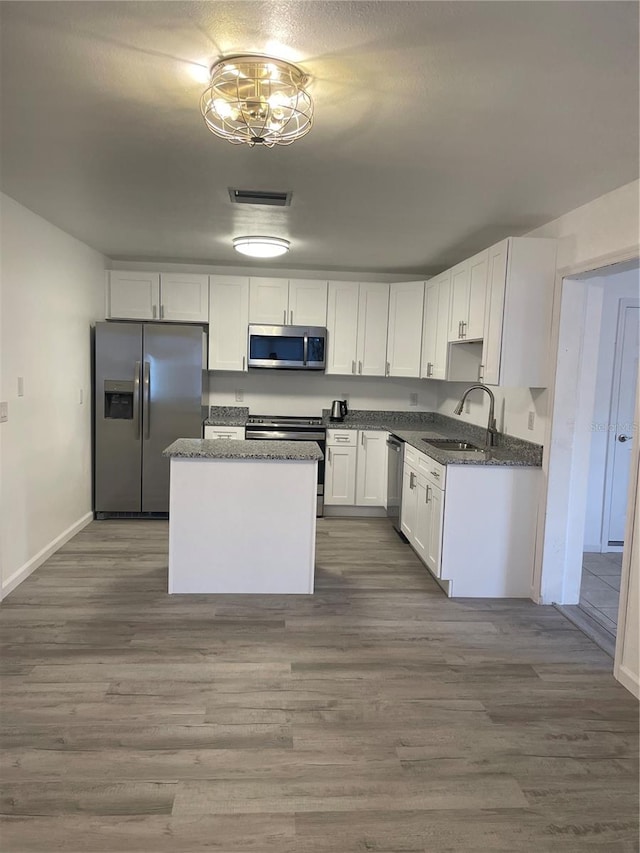 kitchen featuring stainless steel appliances, dark hardwood / wood-style floors, white cabinets, and sink