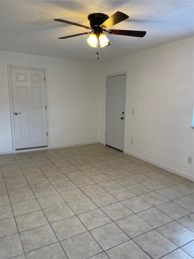 tiled spare room featuring ceiling fan and a textured ceiling