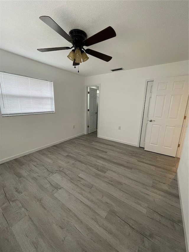 spare room with wood-type flooring, ceiling fan, and a textured ceiling