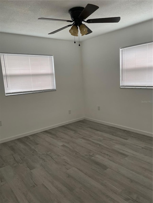 unfurnished room featuring hardwood / wood-style flooring, ceiling fan, a healthy amount of sunlight, and a textured ceiling