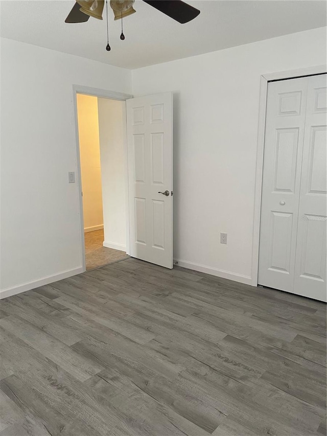 unfurnished bedroom with a closet, wood-type flooring, and ceiling fan