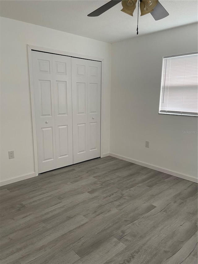 unfurnished bedroom featuring light wood-type flooring, ceiling fan, and a closet