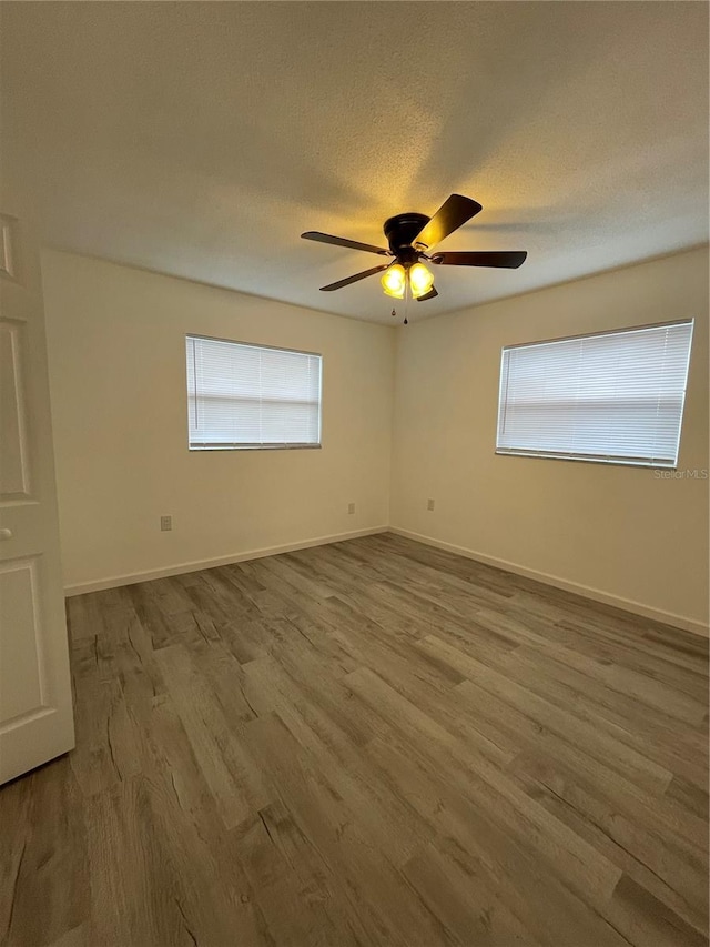 empty room featuring a textured ceiling, hardwood / wood-style flooring, and ceiling fan