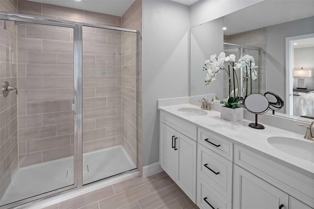 bathroom with tile patterned floors, a shower with door, and vanity