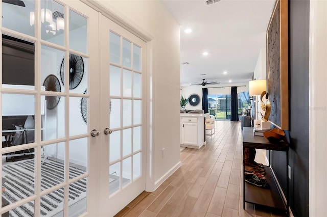 hall featuring french doors and a notable chandelier