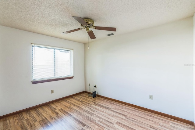 spare room with a textured ceiling, light hardwood / wood-style flooring, and ceiling fan