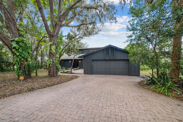4834 Hall Rd, Orlando, FL 32817 - mid-century modern home featuring an attached garage, decorative driveway, and board and batten siding