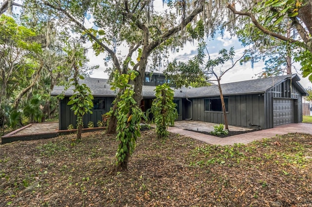 rear view of house featuring a garage and a patio area