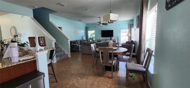 dining room with ceiling fan, light tile patterned floors, and a textured ceiling