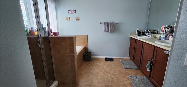 bathroom featuring plus walk in shower, vanity, and tile patterned flooring