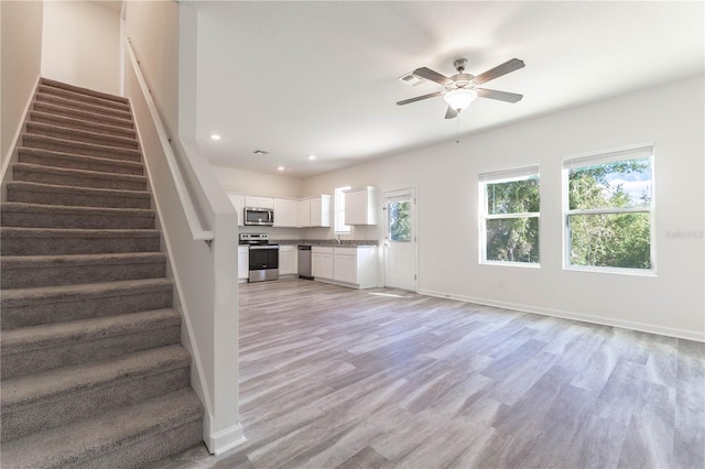 unfurnished living room with light hardwood / wood-style flooring and ceiling fan