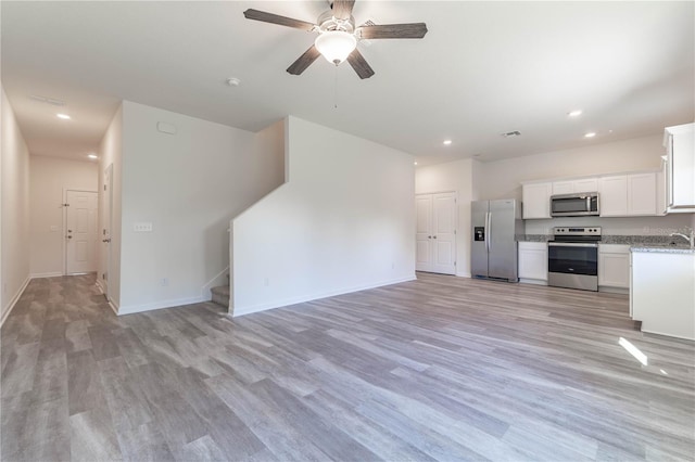 kitchen featuring white cabinetry, ceiling fan, sink, light hardwood / wood-style flooring, and appliances with stainless steel finishes