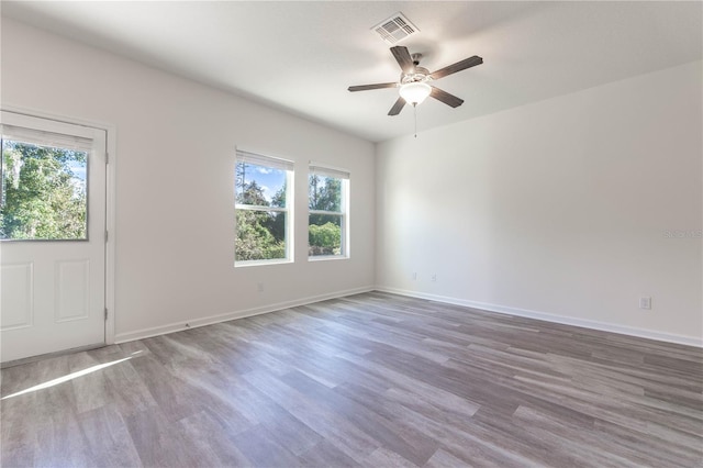 unfurnished room featuring wood-type flooring, a wealth of natural light, and ceiling fan