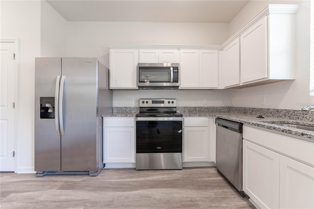 kitchen featuring white cabinetry, light stone countertops, and appliances with stainless steel finishes