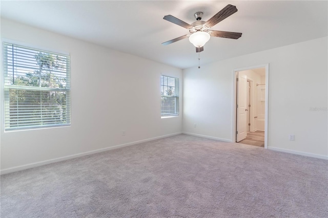 spare room featuring light carpet and ceiling fan