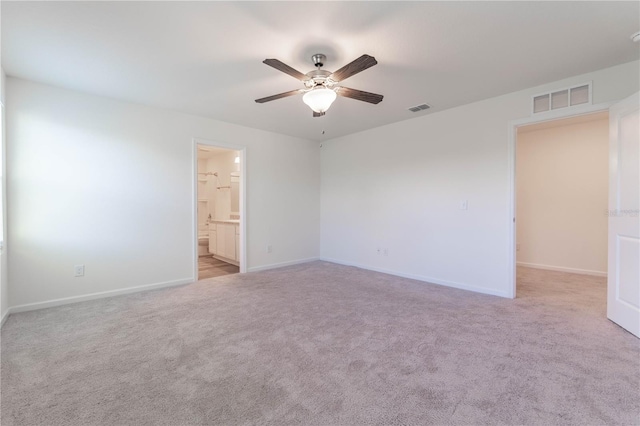 empty room with ceiling fan and light carpet