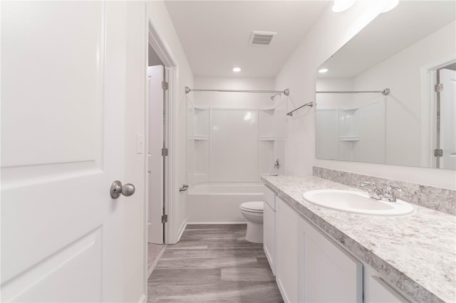 full bathroom with bathing tub / shower combination, vanity, hardwood / wood-style flooring, and toilet