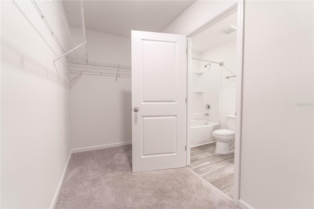 spacious closet featuring light colored carpet