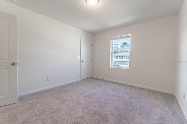 unfurnished room with light carpet