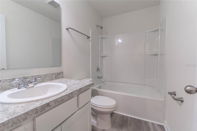 full bathroom with hardwood / wood-style floors, vanity, toilet, and shower / bath combination