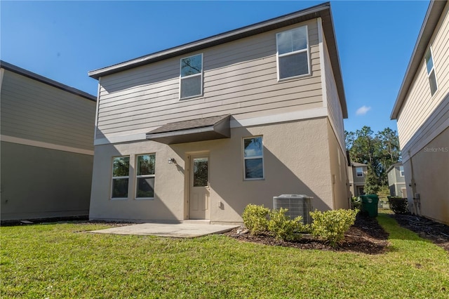 rear view of house with a yard, central AC, and a patio area