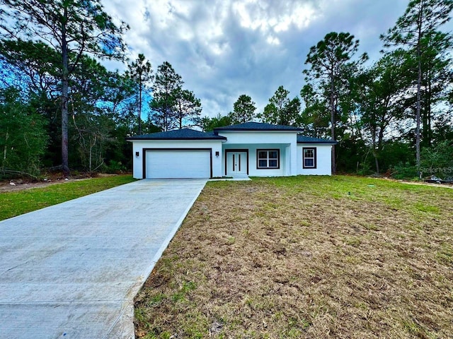 view of front of home with a garage and a front lawn