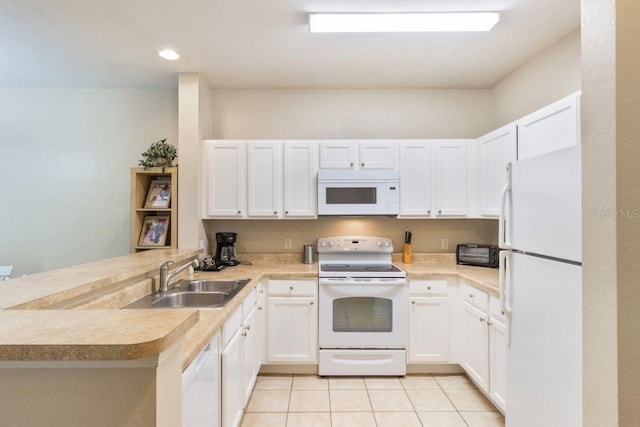 kitchen featuring white cabinets, white appliances, sink, and kitchen peninsula