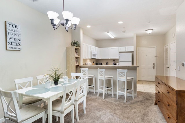 carpeted dining space with a chandelier