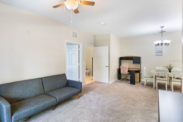 living room featuring ceiling fan with notable chandelier and carpet flooring