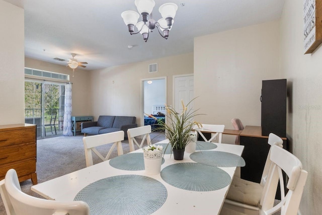 carpeted dining area featuring ceiling fan with notable chandelier