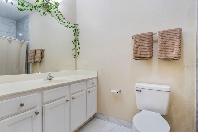 bathroom featuring toilet, vanity, and curtained shower