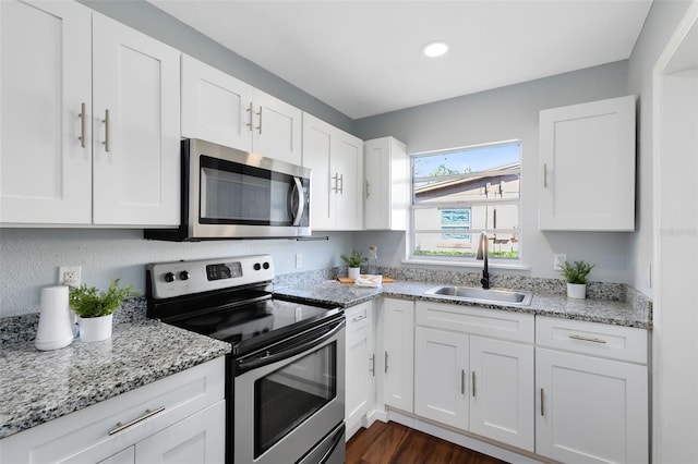 kitchen with a sink, appliances with stainless steel finishes, and white cabinets