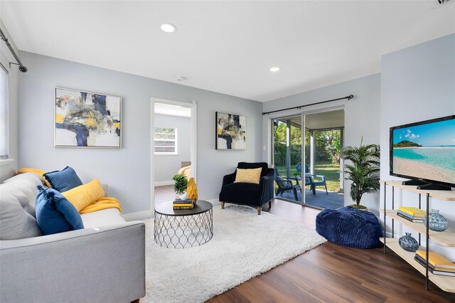 living area featuring baseboards, wood finished floors, and recessed lighting