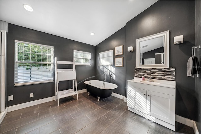 bathroom featuring vanity, backsplash, a bath, vaulted ceiling, and hardwood / wood-style flooring