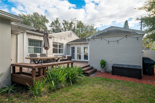 rear view of house featuring french doors, a yard, and a wooden deck