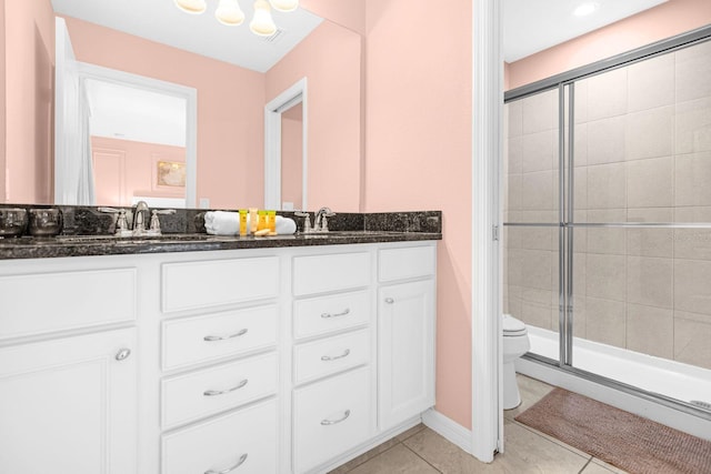 bathroom featuring tile patterned floors, a shower with door, vanity, and toilet