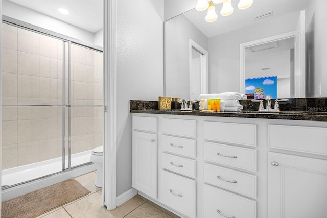 bathroom with tile patterned flooring, vanity, a shower with shower door, and toilet