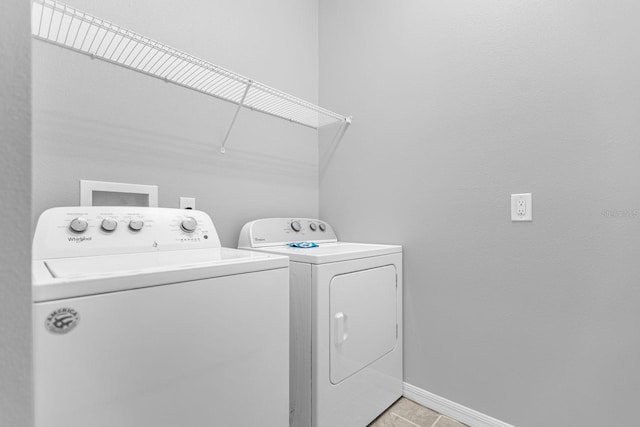 laundry room featuring washing machine and clothes dryer and light tile patterned floors