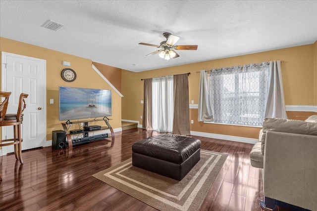 living room with ceiling fan, a textured ceiling, and hardwood / wood-style flooring