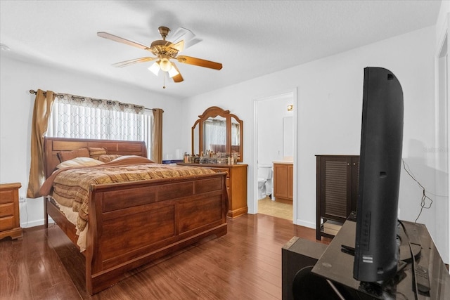 bedroom with ceiling fan, ensuite bathroom, and dark hardwood / wood-style flooring