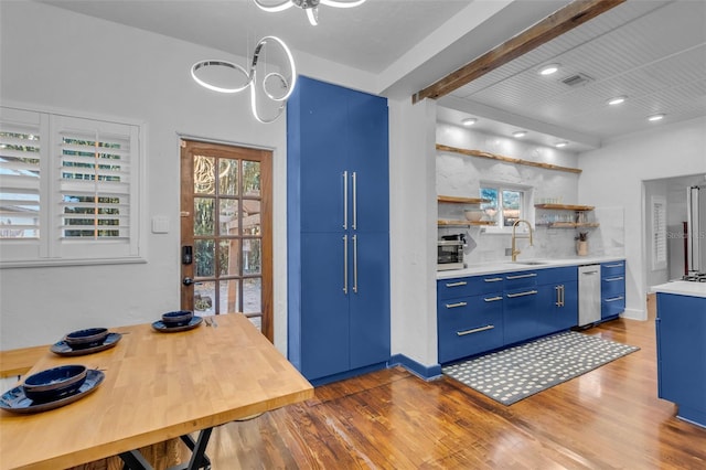 kitchen featuring hardwood / wood-style flooring, blue cabinets, sink, and stainless steel appliances