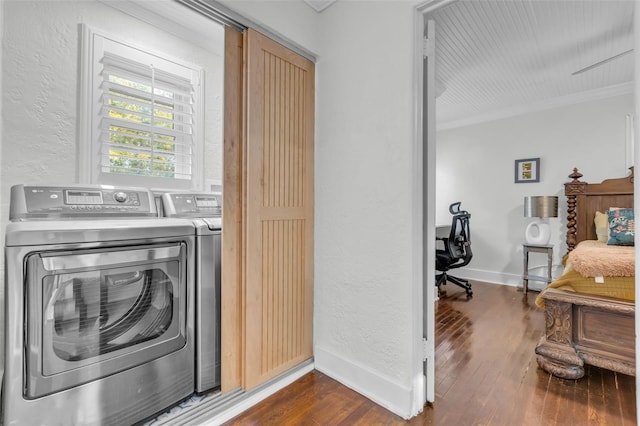 washroom with dark hardwood / wood-style floors, crown molding, and washing machine and clothes dryer