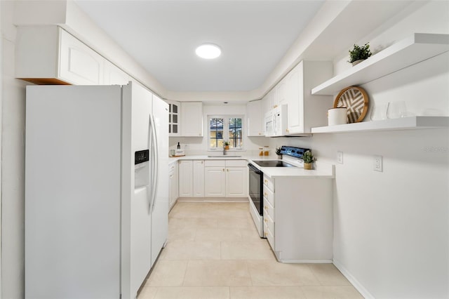 kitchen featuring sink, white appliances, and white cabinetry