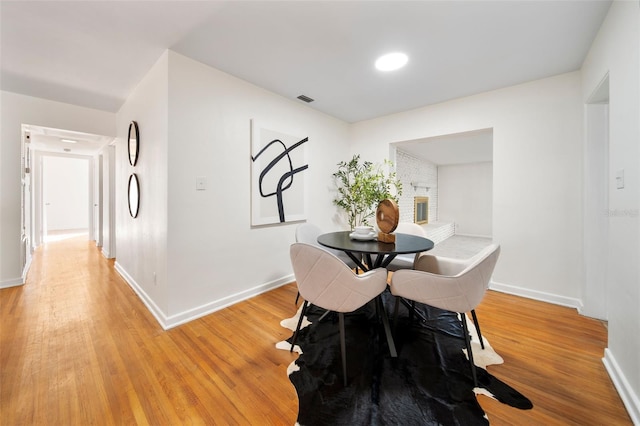 dining room featuring a fireplace and light hardwood / wood-style floors