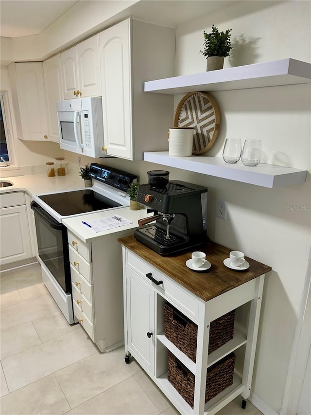 kitchen featuring wooden counters, electric stove, light tile patterned floors, and white cabinetry