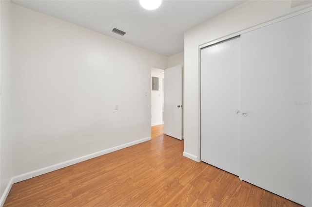 unfurnished bedroom with light wood-type flooring and a closet