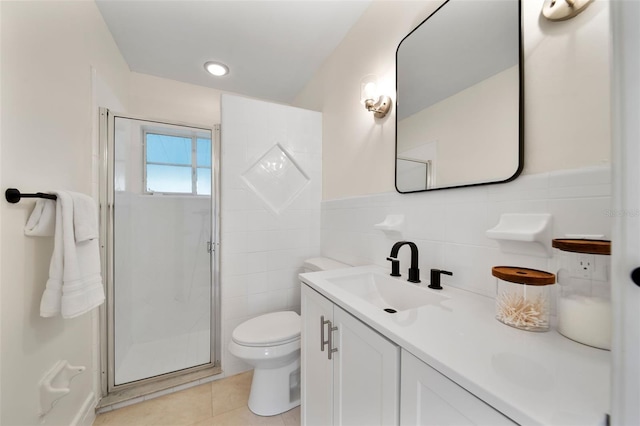 bathroom with tile patterned flooring, tile walls, toilet, an enclosed shower, and vanity