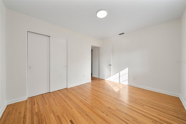 unfurnished bedroom featuring a closet and light hardwood / wood-style floors