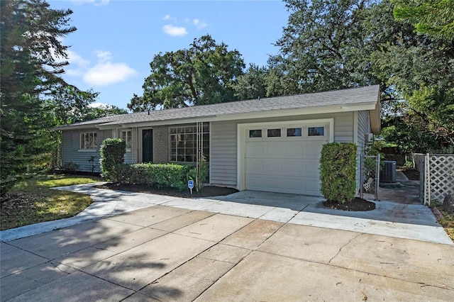 single story home with a garage and central AC unit