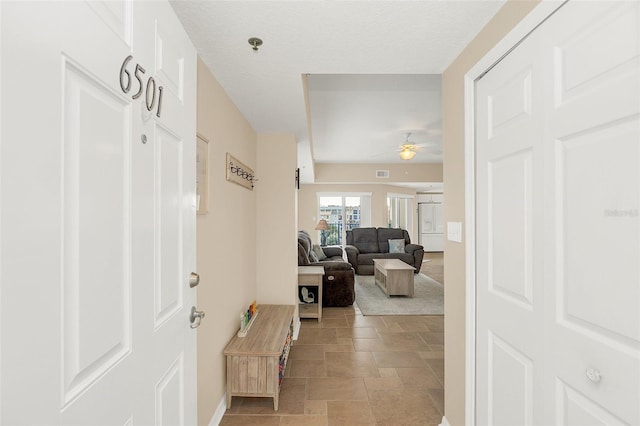 carpeted entrance foyer with ceiling fan